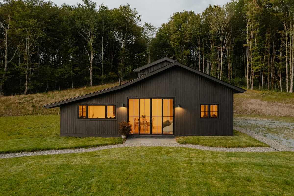 A sleek modern barndominium with a dark gabled facade, representative of ArchPermits' barn house permit drawings.