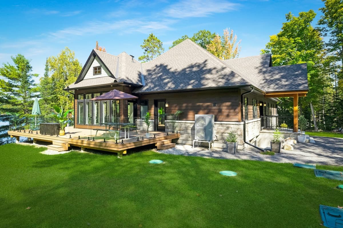 A modern waterfront lake house with a wraparound deck, representative of ArchPermits' lake house permit drawings.