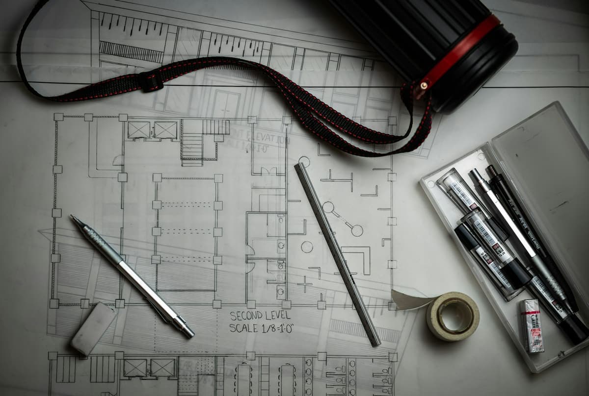 Detailed architectural shop drawings with drafting tools, representative of ArchPermits' shop drawing services.